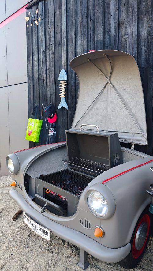 Klassischer Kleintransporter mit geöffneter Fronthaube vor einer Holzwand