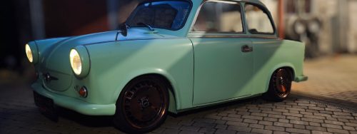 Restaurierter klassischer Kleinwagen mit leuchtenden Scheinwerfern bei Nacht